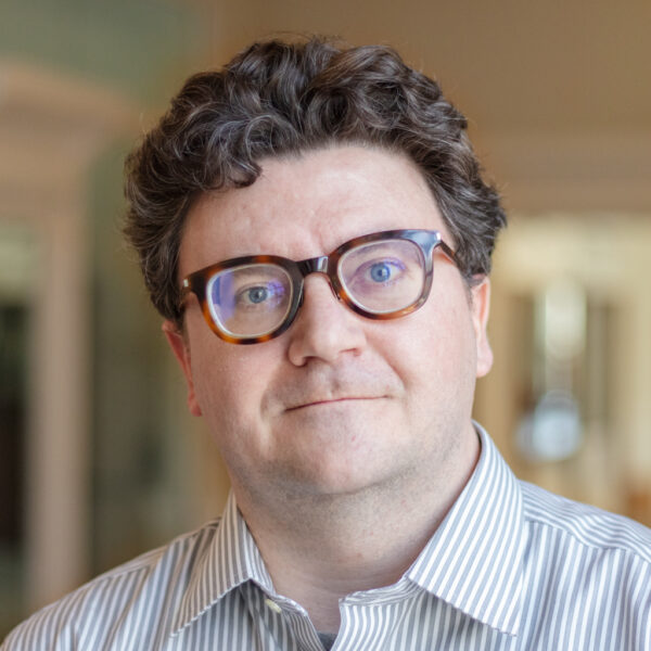 http://Headshot%20of%20Cody%20Carvel%20from%20the%20shoulders%20up,%20in%20strip%20button%20down%20with%20glasses.